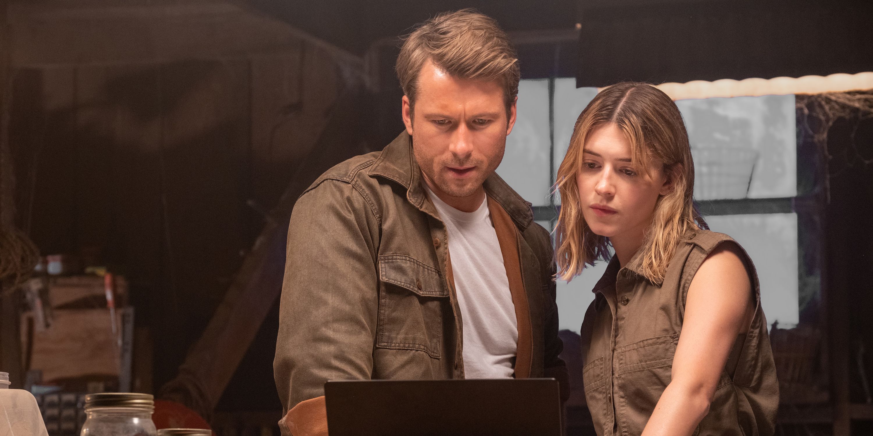 Glen Powell and Daisy Edgar-Jones look at a laptop in Twisters.