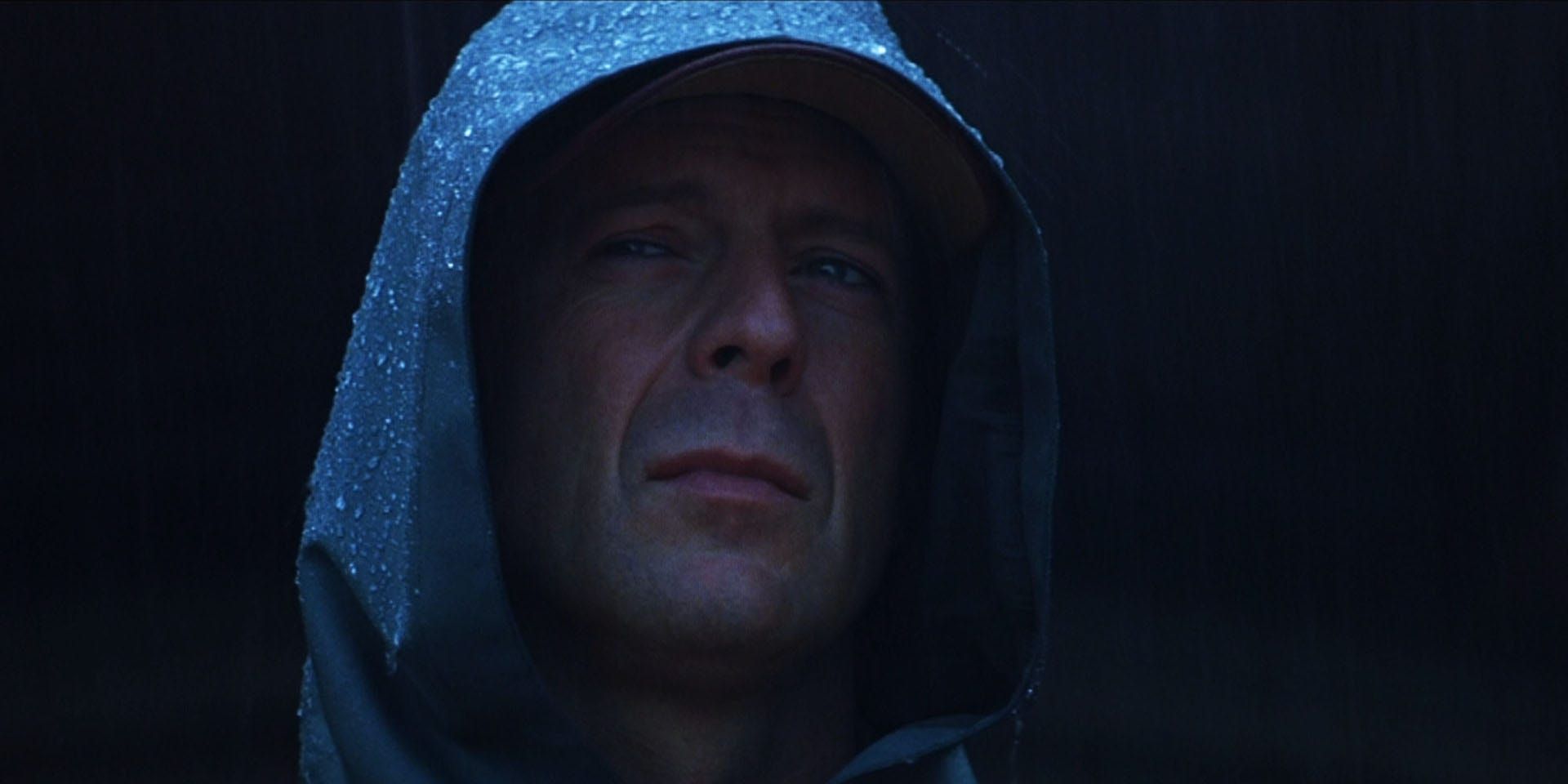 Bruce Willis stands in the rain, in a slicker, in M. Night Shyamalan's 'Unbreakable'