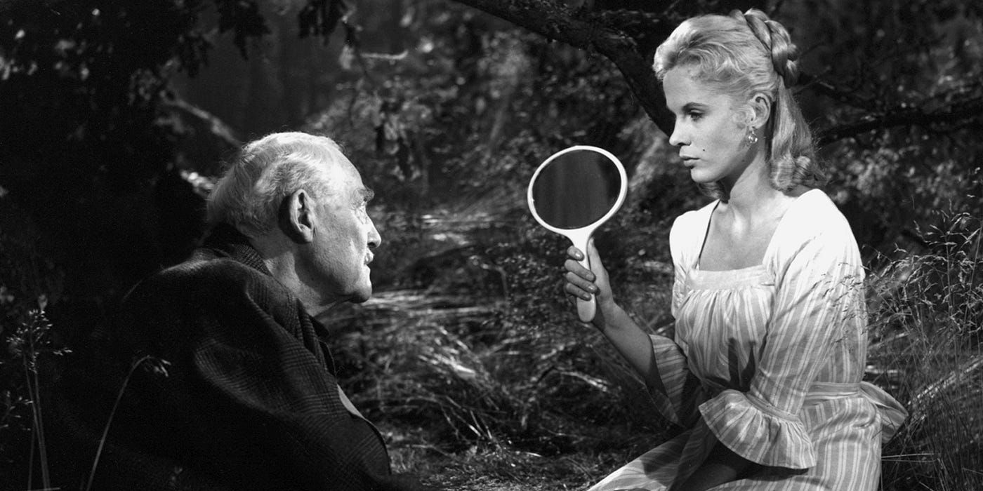 A woman holding a mirror while talking to a man in Wild Strawberries 1-1