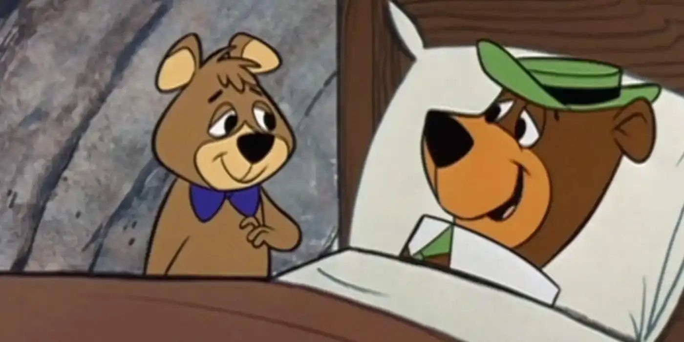 Yogi Bear sleeping in bed while Boo-Boo watches