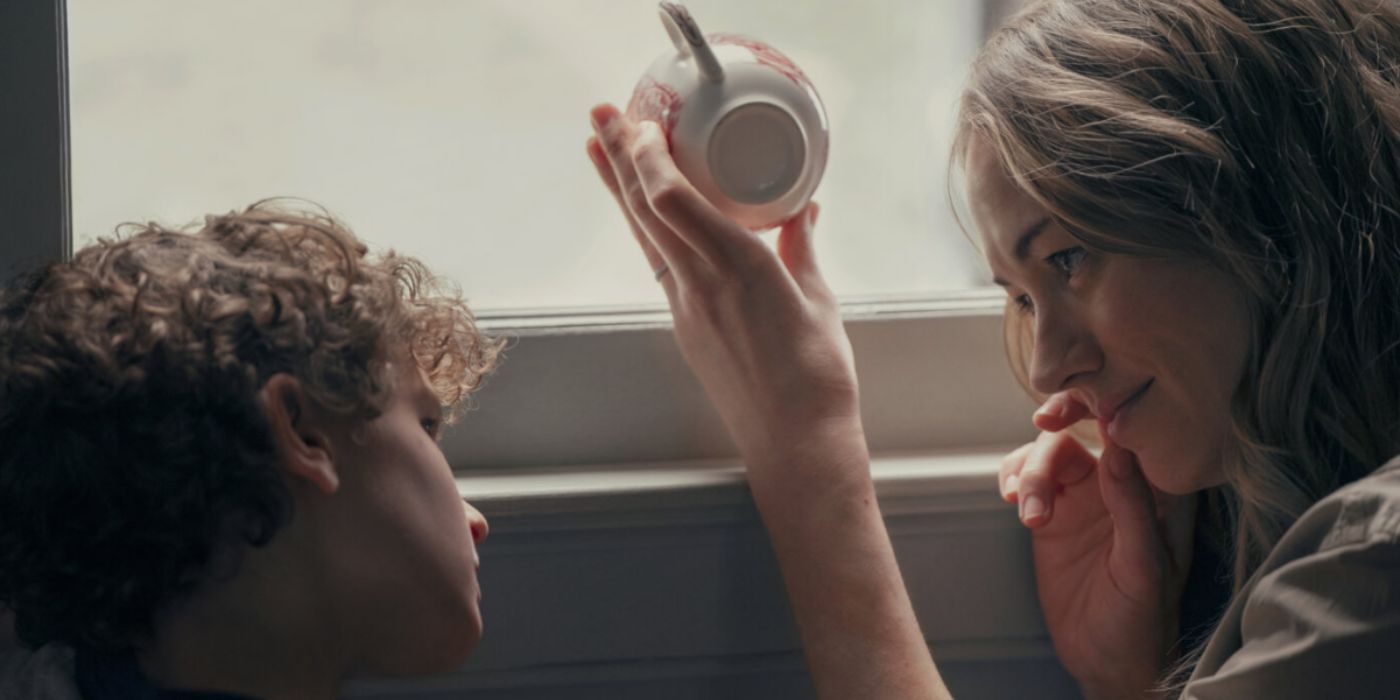 Yvonne Strahovski holding a teacup while sitting next to a boy in 'Teacup' series.