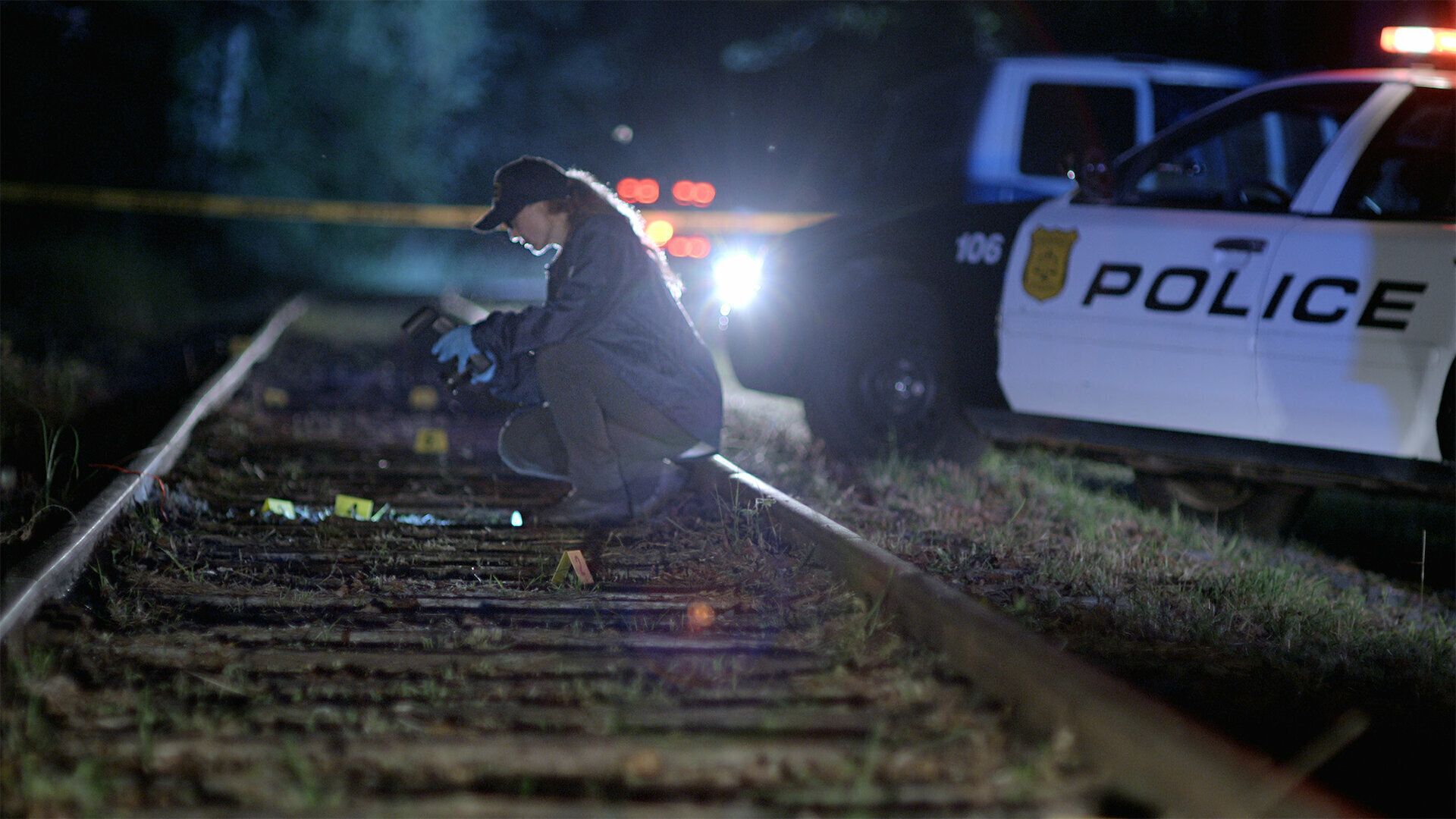 A cop takes crime scene photos on Unsolved Mysteries