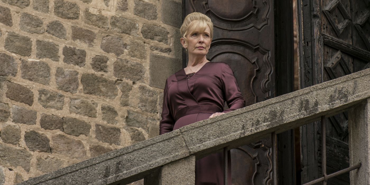 Ysabeau de Clermont (Lindsay Duncan) standing on a large stone and brick castle balcony looking toward the right in A Discovery of Witches