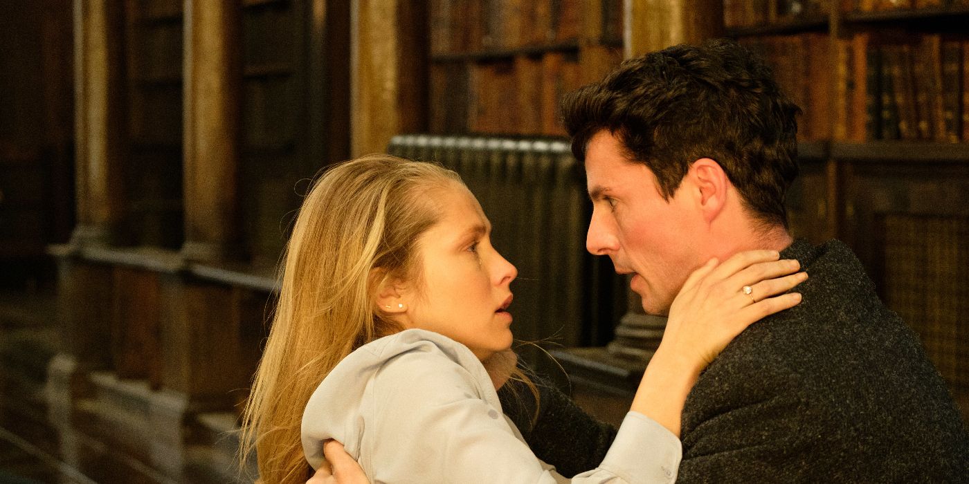 Matthew Clairmont (Matthew Goode) holding a distressed Diana Bishop (Teresa Palmer), who clings to him as they stare into each other's eyes in the Oxford library in A Discovery of Witches