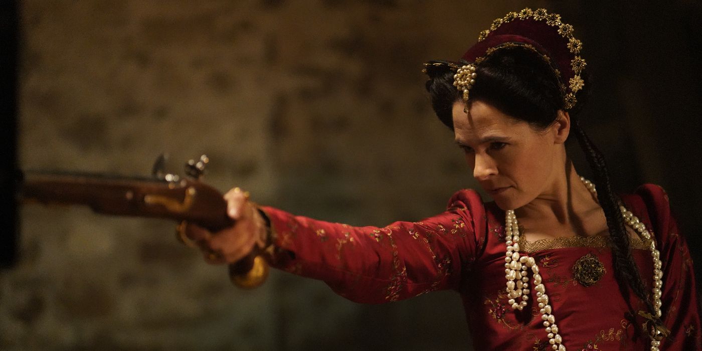 Louisa de Clermont (Elaine Cassidy) facing the left and aiming a gun while wearing Elizabethan England style clothing in A Discovery of Witches