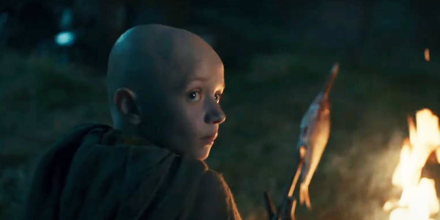 A screenshot of Dexter Sol Ansell as Egg roasting a fish in front of a fire in A Knight of the Seven Kingdoms