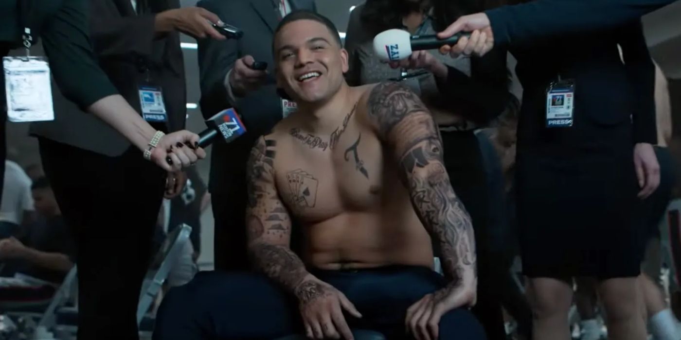 Josh Rivera as a shirtless and tattooed Aaron Hernandez surrounded by media in American Sports Story