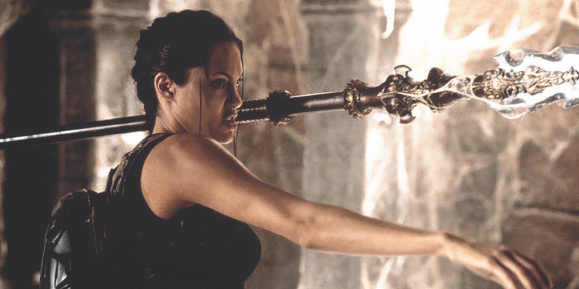 Angelina Jolie as Lara Croft holding a spear in Lara Croft: Tomb Raider.