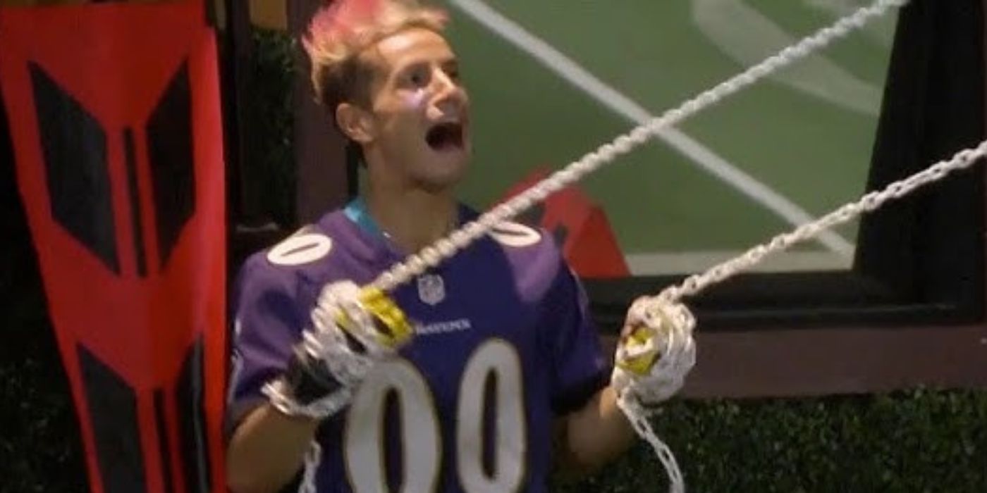 Frankie holding two ropes, his mouth open during a competition on Big Brother