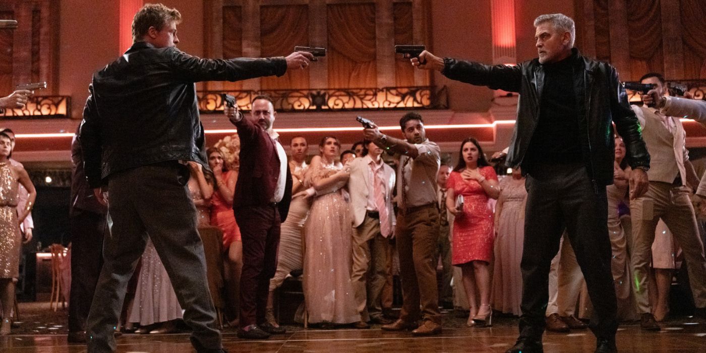 Brad Pitt and George Clooney pointing their pistols at one another while standing in a ballroom in Wolfs.