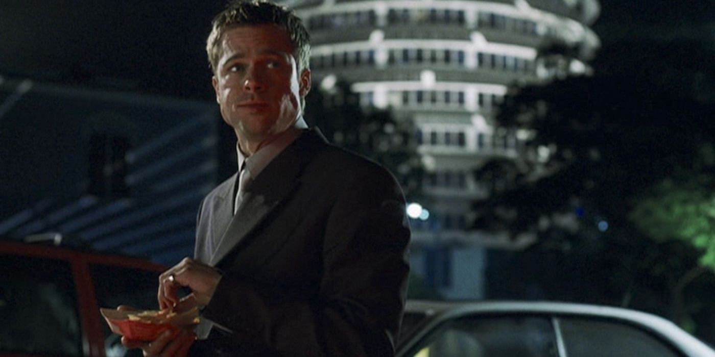 Brad Pitt is eating a shrimp cocktail while standing outside in Ocean's Eleven.