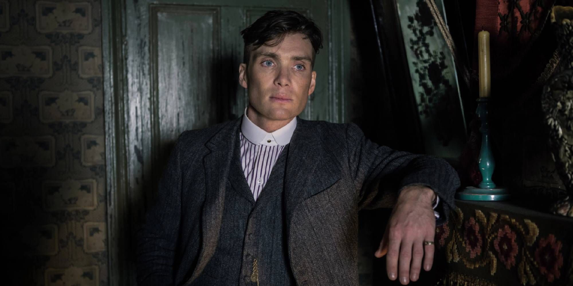 Cillian Murphy as Tommy Shelby leaning against a cabinet in Peaky Blinders