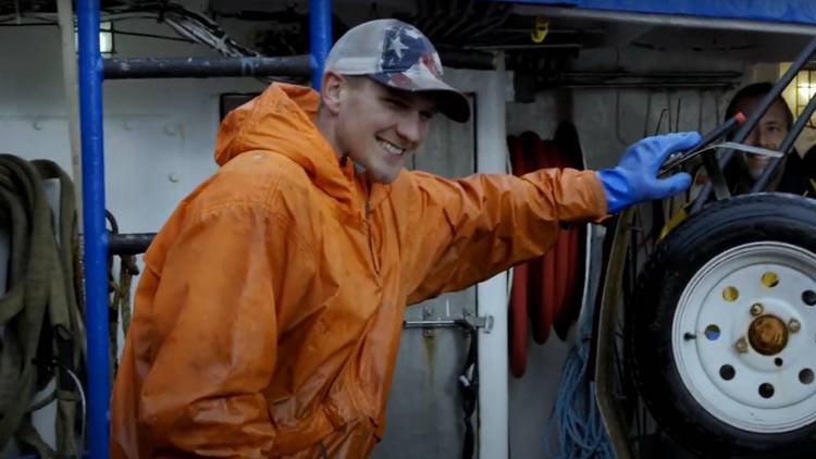 Clark Pederson with his arm reaching for something on the FV Northwestern in Deadliest Catch
