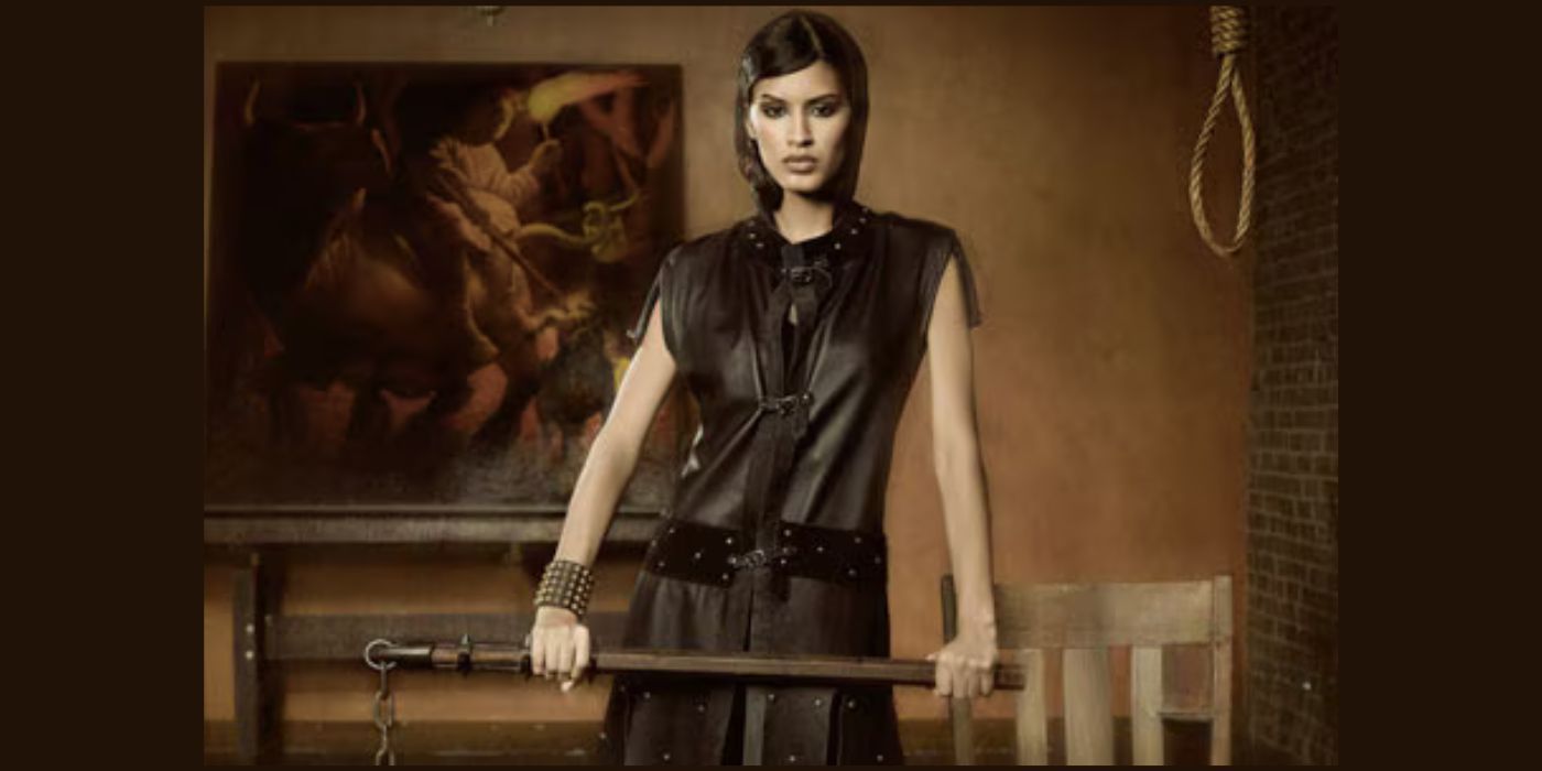 Jaslene Gonzalez holds a stylized weapon and has a noose hanging in the background on a photo shoot for America's Next Top Model.