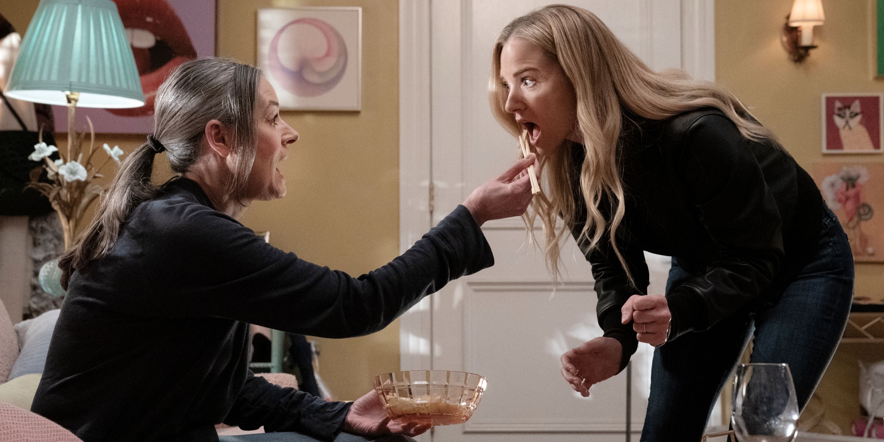 Paget Brewster as Emily Prentiss feeding snacks out of a bowl to A.J. Cook as JJ in Criminal Minds: Evolution