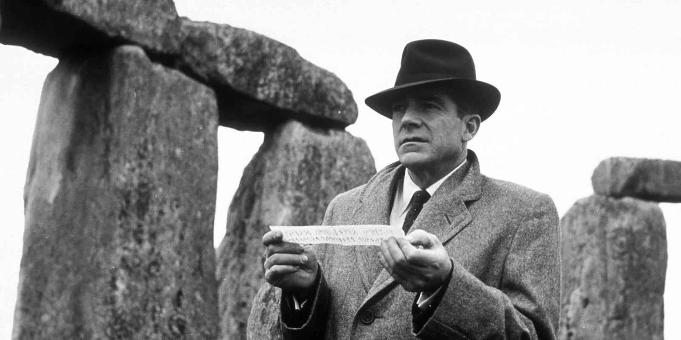 A man standing near a stone structure in Curse of the Demon