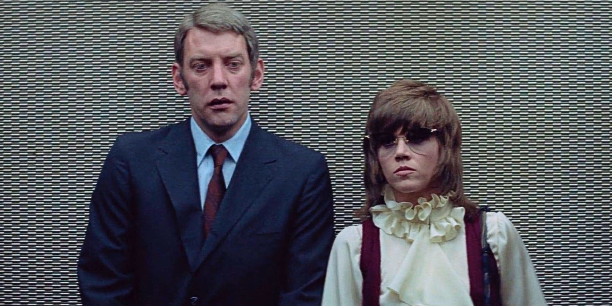 Donald Sutherland standing next to Jane Fonda in Klute (1971).