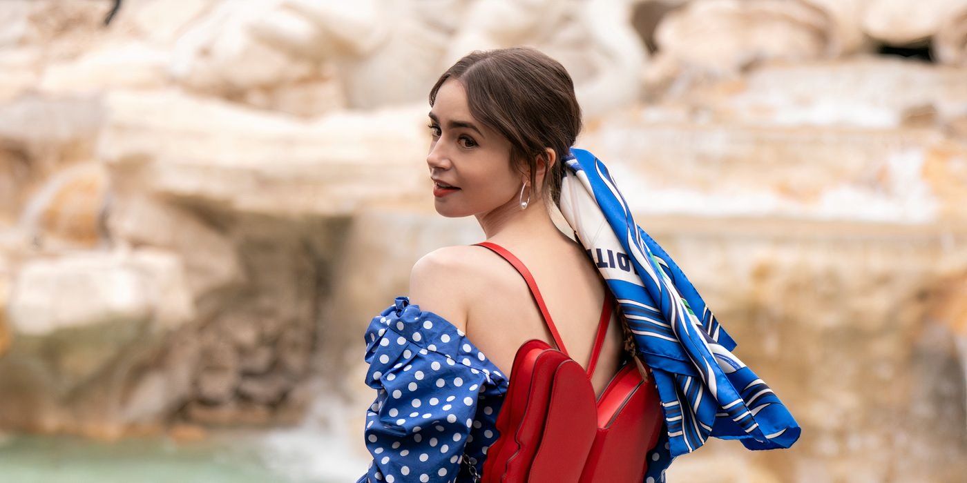 Lily Collins lleva un vestido rojo y un top azul y blanco.