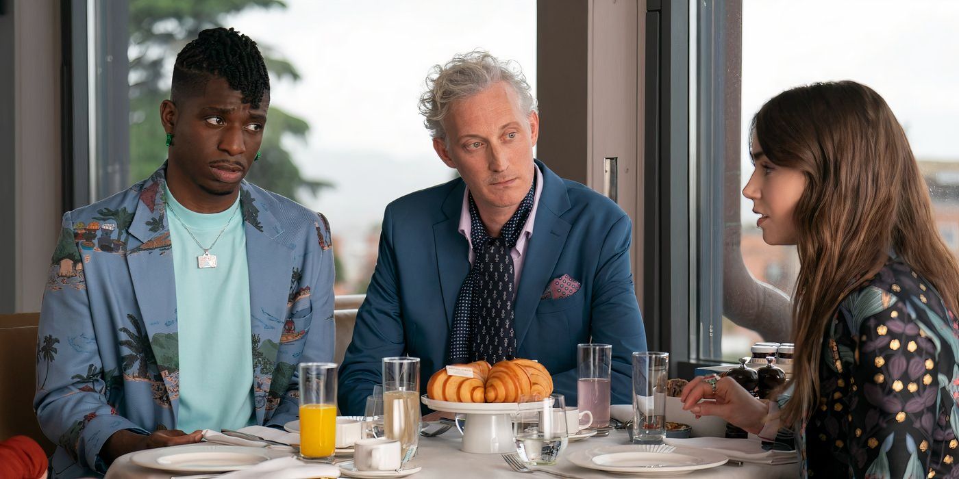 samuel arnold wears a light blue tee shirt with a blue overcoat and sits next to bruno gouery who is in a blue suit coat with a pink shirt