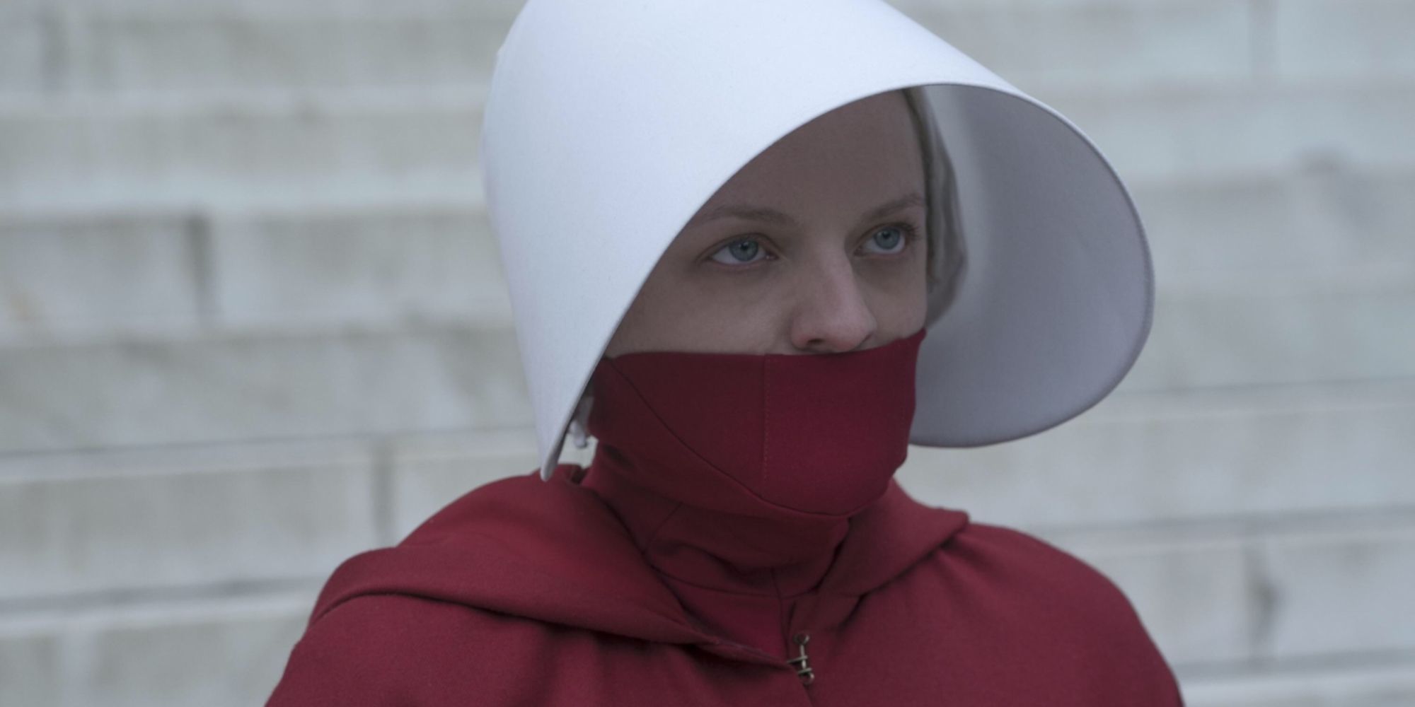 Offred in The Handmaid's Tale wearing a red uniform covering her mouth and wide white hat.