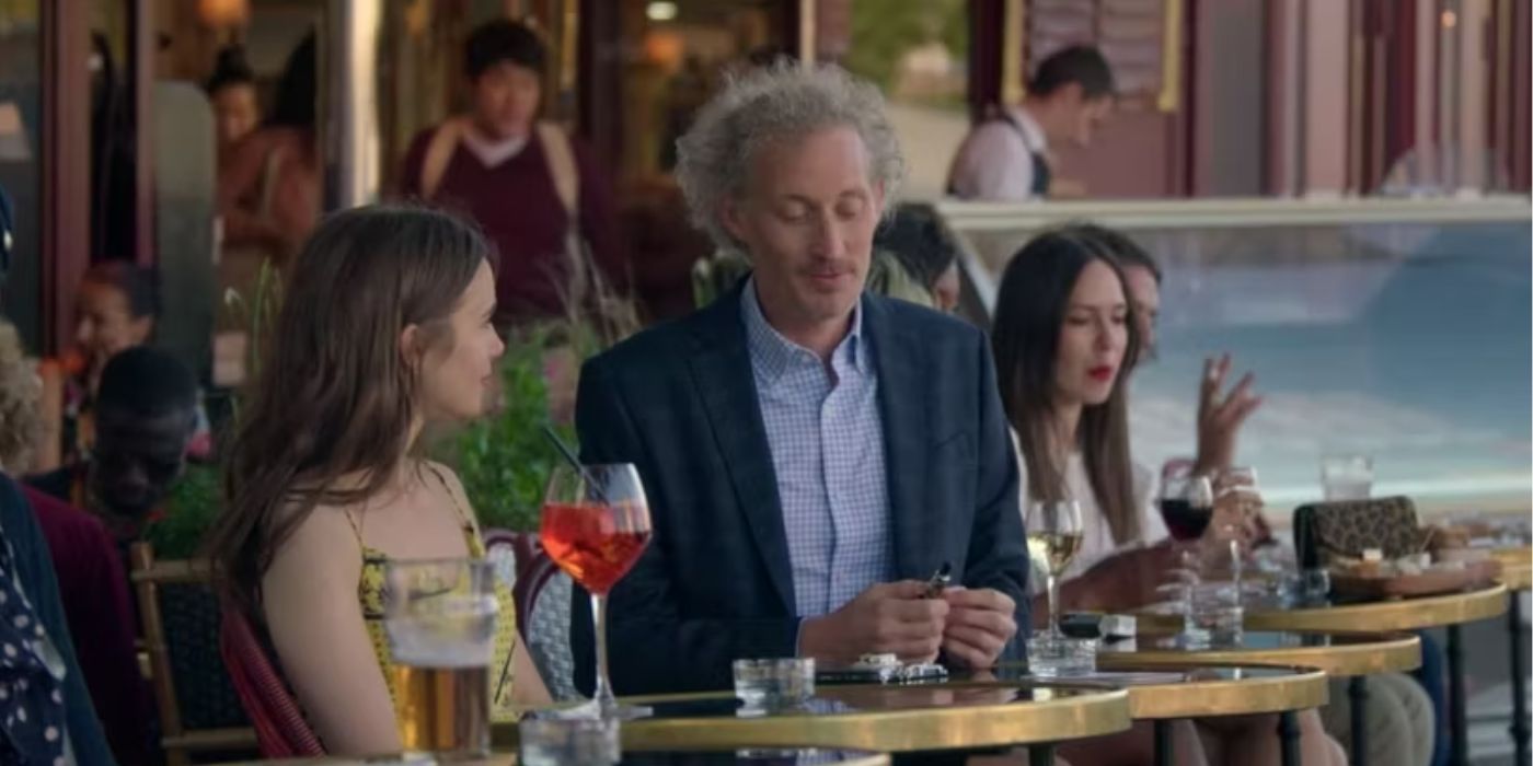 Bruno Goery sitting next to Lily Collins in a coffee shop in a scene from 'Emily in Paris' Season 1.