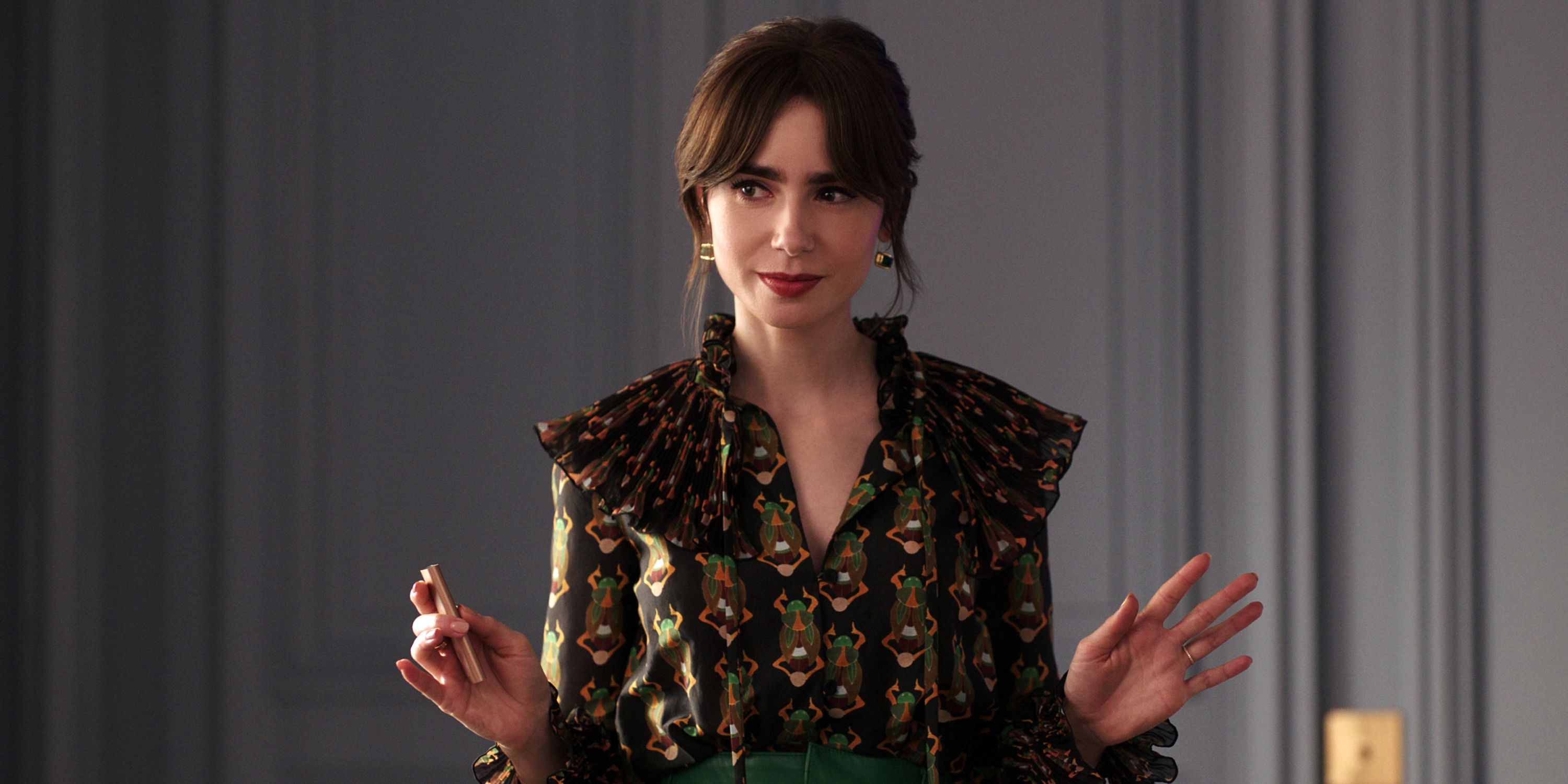 Lily Collins as Emily Cooper in a black patterned shirt with her hands up in Season 4 Part 1 of Emily in Paris