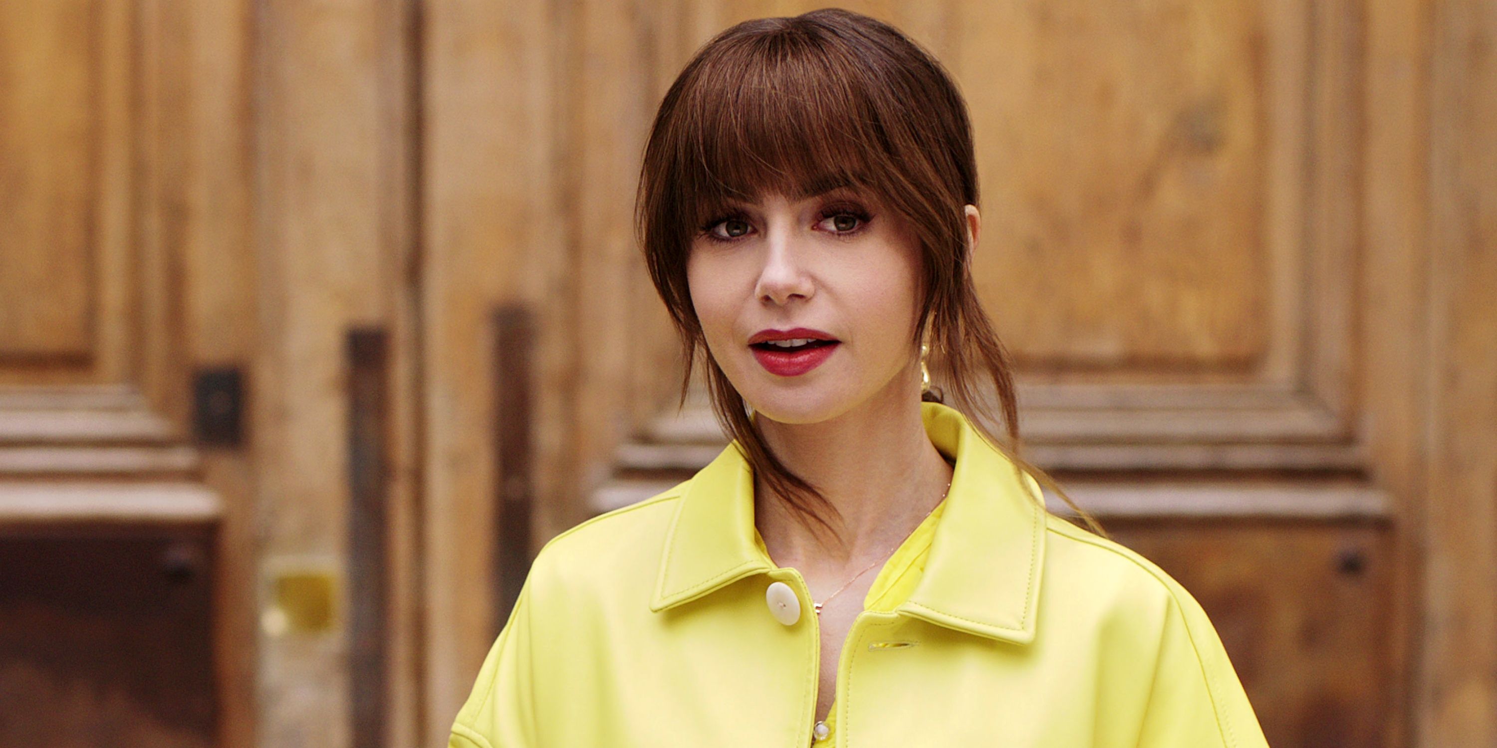 Lily Collins as Emily Cooper in a yellow top while outdoors in Season 4 Part 1 of Emily in Paris