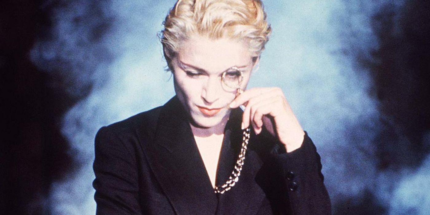 Madonna with a monocle on her left eye and smoke in the backgroun in the "Express Yourself" video