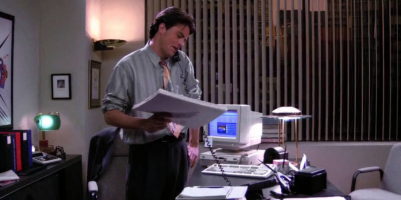 Chandler in his office holding papers with a phone to his ear on Friends.