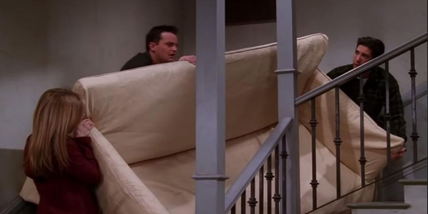 Rachel, Chandler, and Ross from 'Friends' carrying a couch up a flight of stairs. 