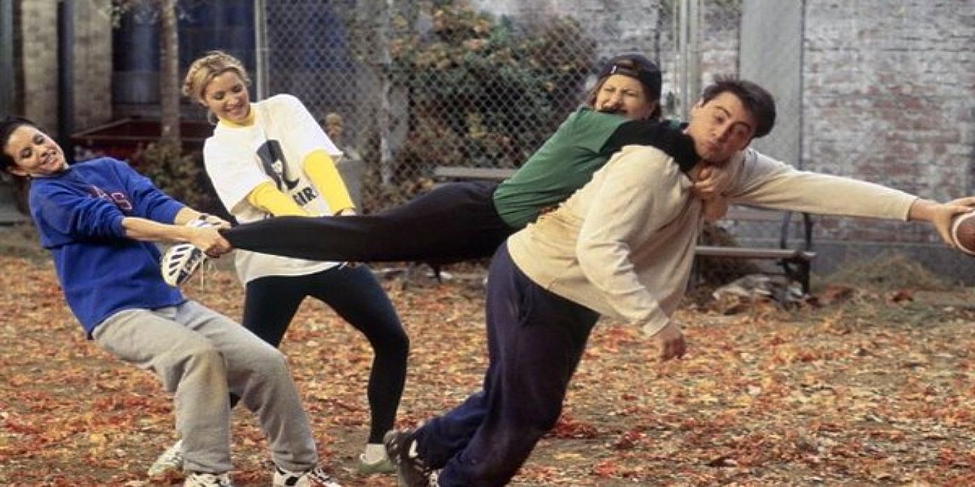 Monica and Phoebe holding Rachel&rsquo;s legs as she hangs off of Joey&rsquo;s back to slow him down during a game of football in &lsquo;Friends&rsquo;.