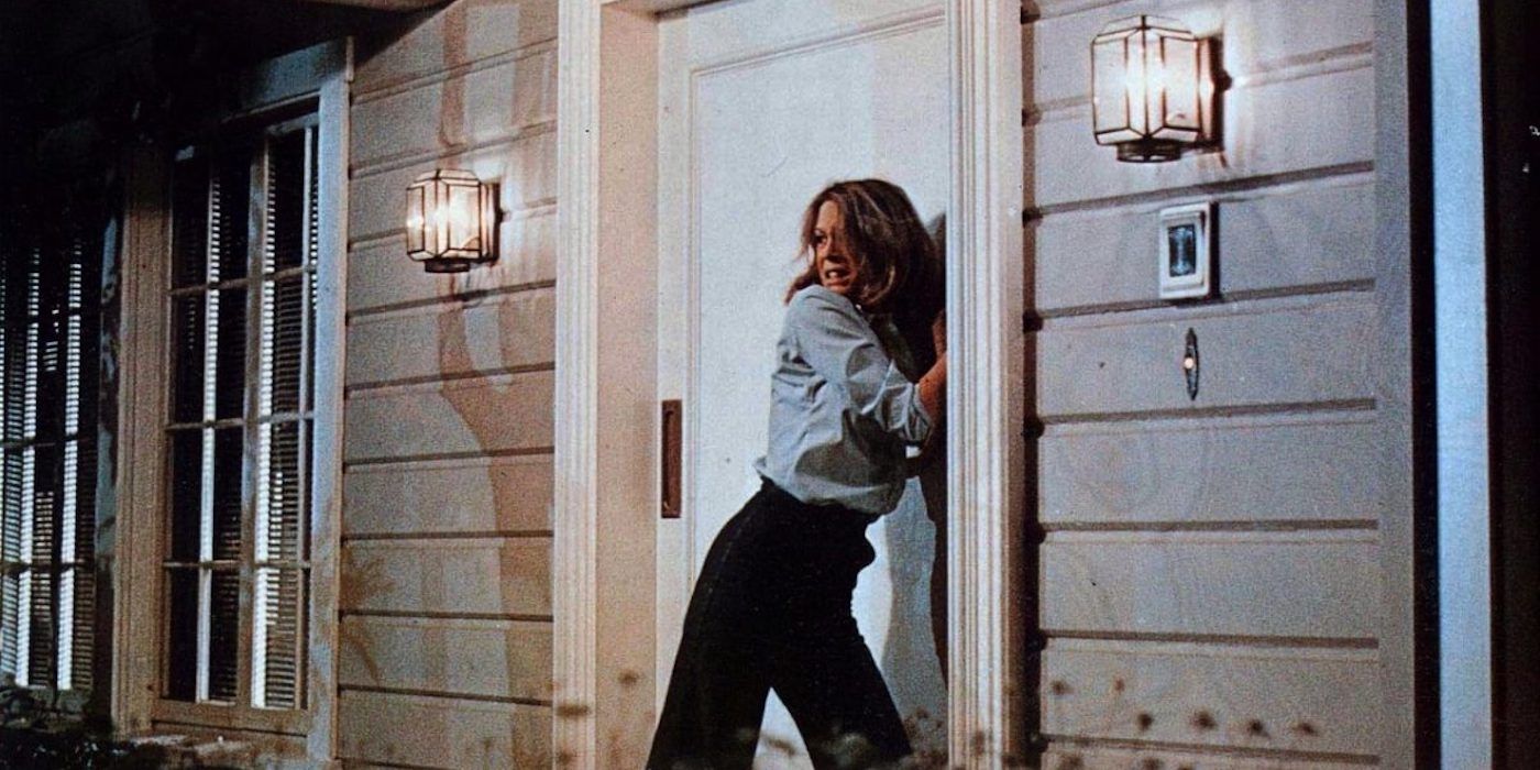 Jamie Lee Curtis outside a front door, fearfully looking back in Halloween