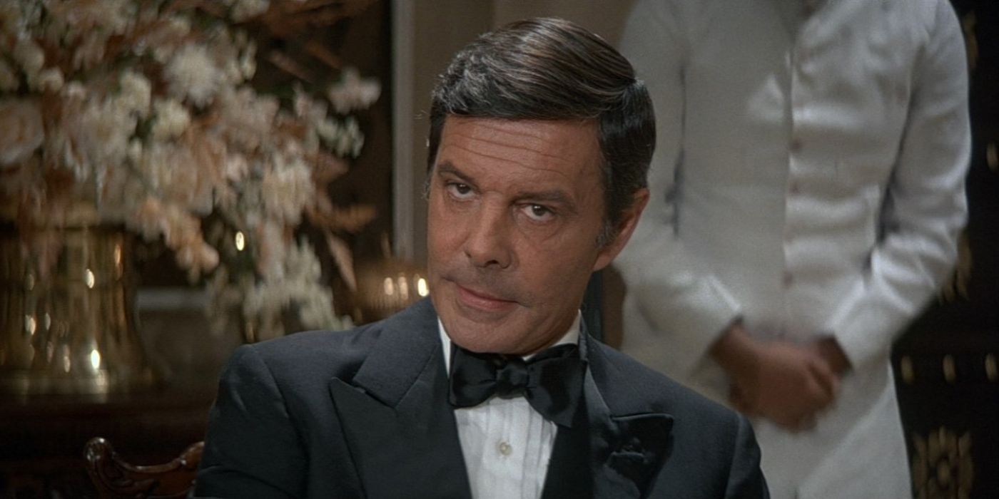 Kamal Khan (Louis Jourdan) sits in a restaurant wearing a tuxedo in 'Octopussy' (1983).