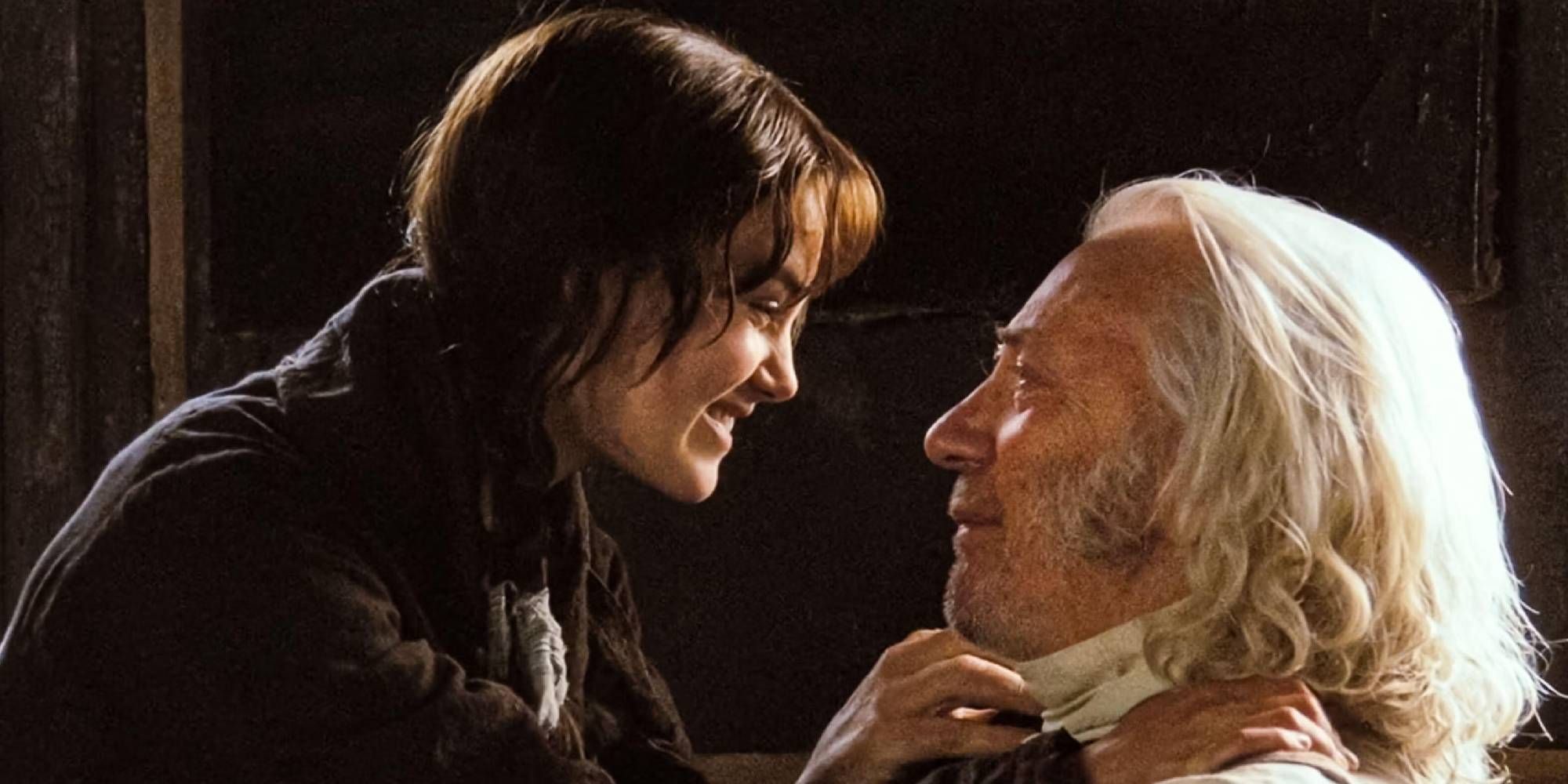 Keira Knightley as Elizabeth and Donald Sutherland as Mr. Bennett in Pride & Prejudice look at each other smiling.