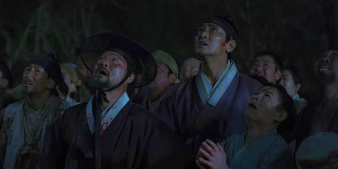 Kim Sang-ho and Ju Ji-hoon as Mu-yeong and Lee Chang standing in a crowd at night looking up in Kingdom