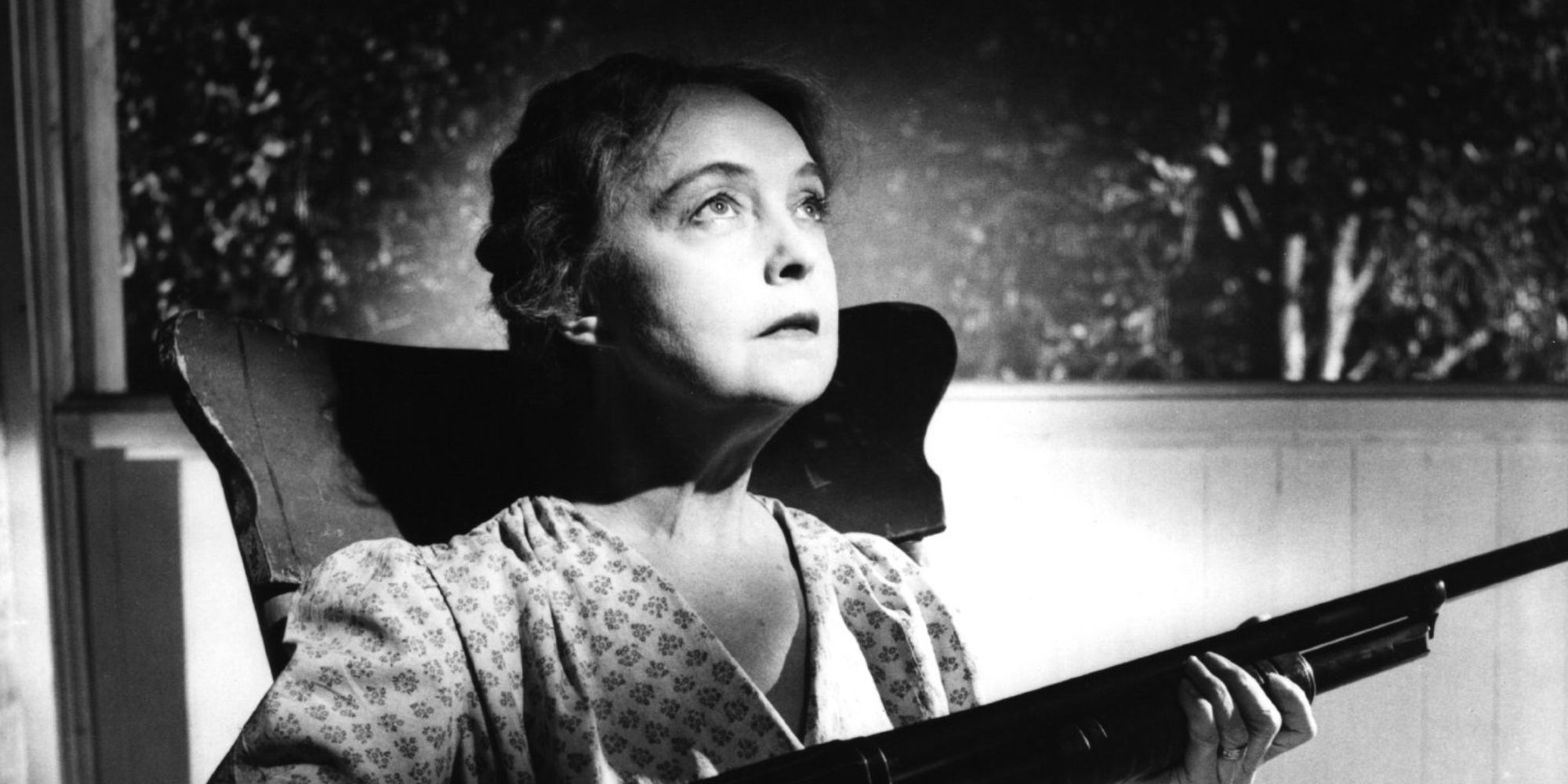 Lillian Gish as Rachel Cooper holding a rifle in The Night of the Hunter (1955)