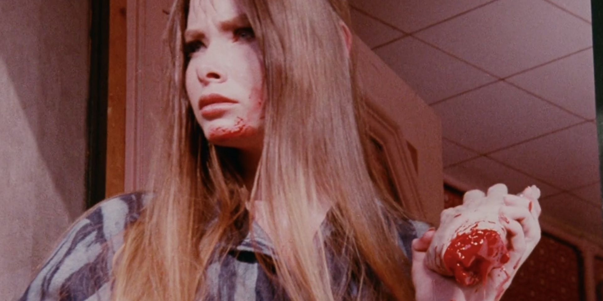 Lynn Lowry as Carrie in I Drink Your Blood holding a severed hand.