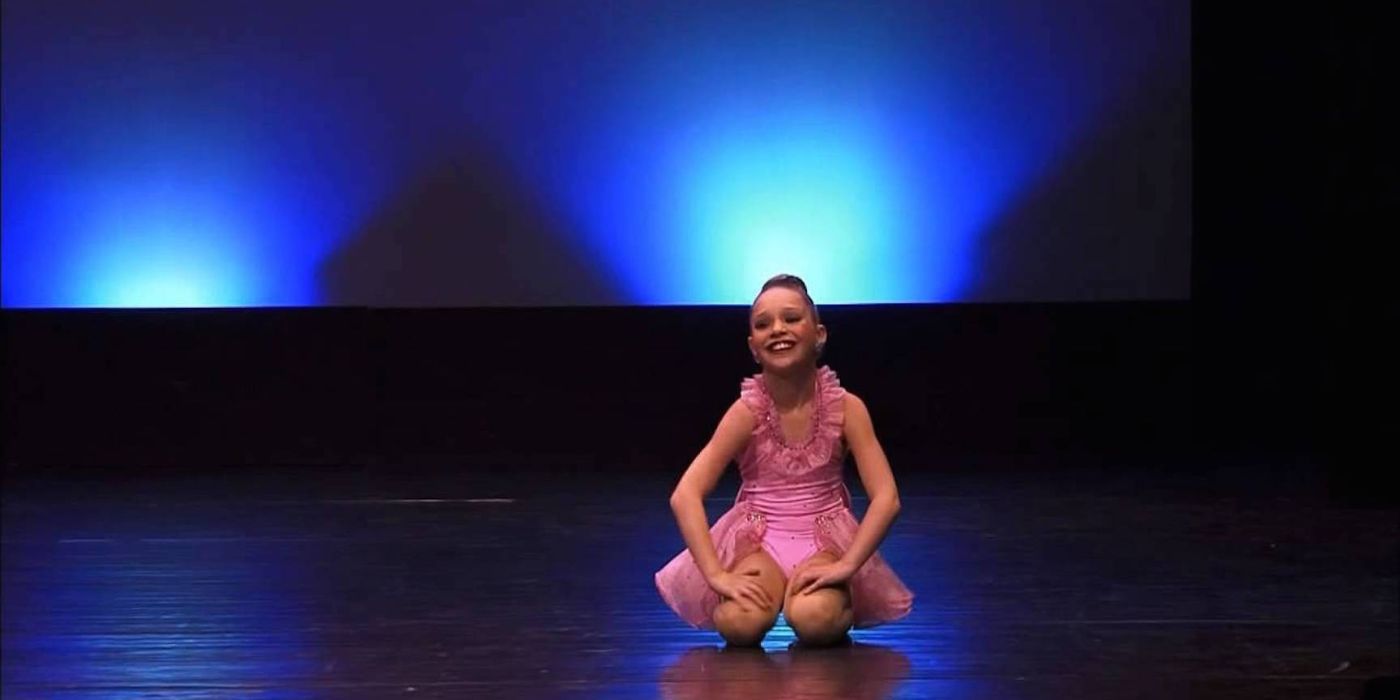 Maddie Ziegler wearing a pink costume onstage in 'Dance Moms'