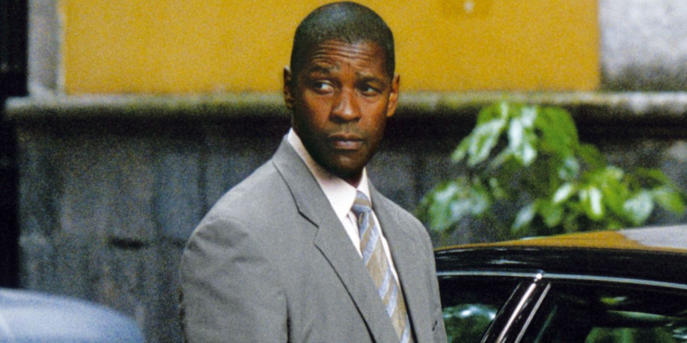 Denzel Washington's John Creasy stands by a car and looks off camera in Man on Fire