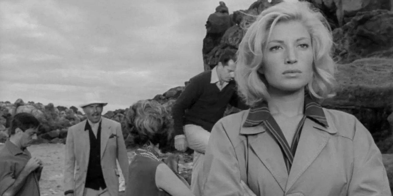 Monica Vitti walking while a man follows her in L&rsquo;Avventura