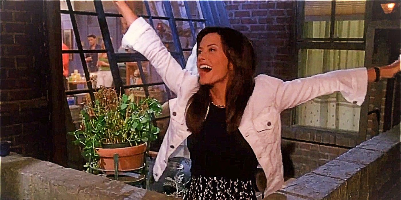 Monica Geller cheers with her arms outstretched over the balcony in season 7 of Friends