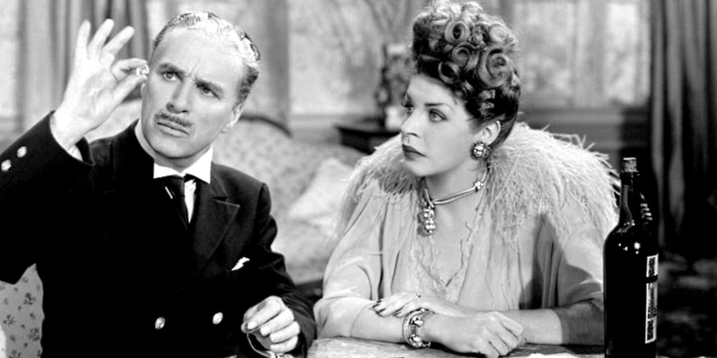 Charlie Chaplin as Henri Verdoux examining a jewel in front of Martha Raye as Annabella Bonheur