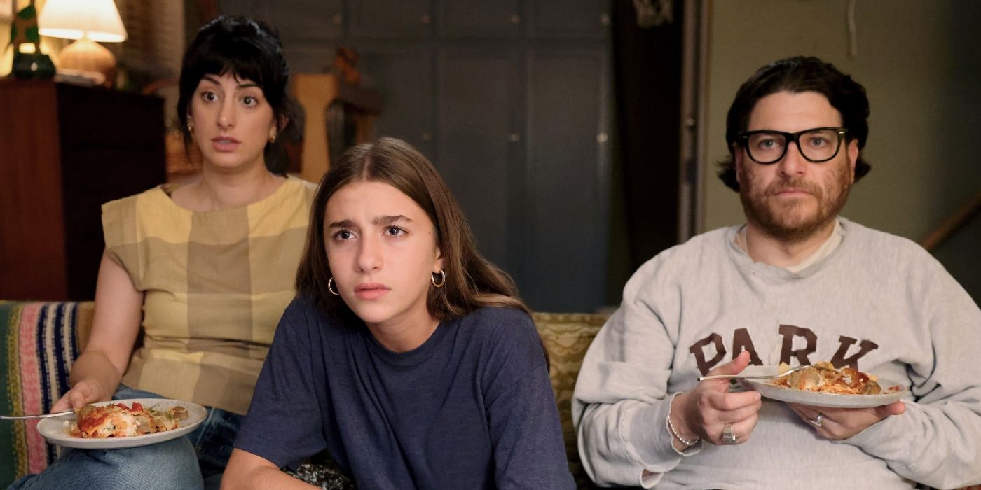 Adam Pally's Danny, Ayden Mayeri's Samantha, and Layla Scalisi's Charlie eating dinner on the couch in Mr. Throwback. 