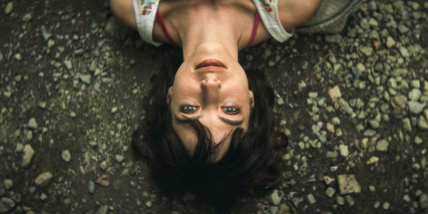 A woman lays upside down on the ground in My First Film. 