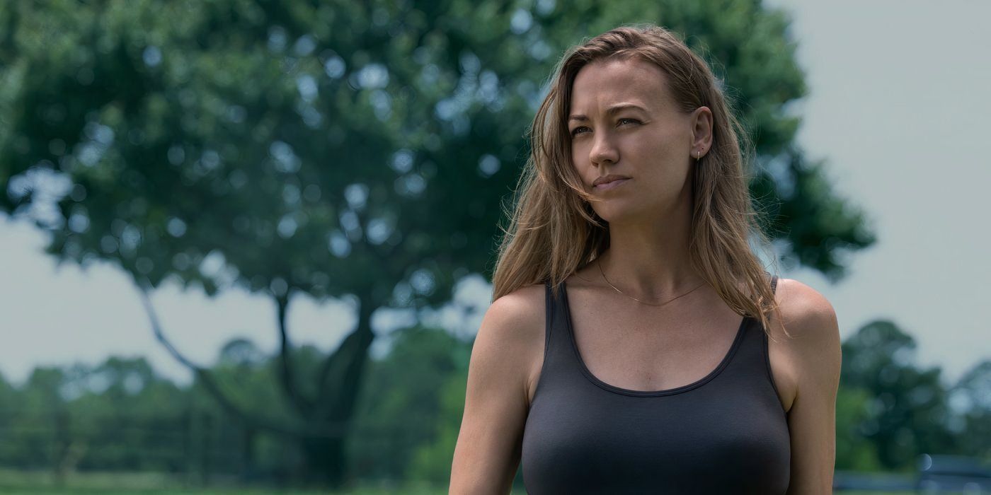 yvonne strahovski's 'teacup' character wears a gray tanktop and stands in front of trees