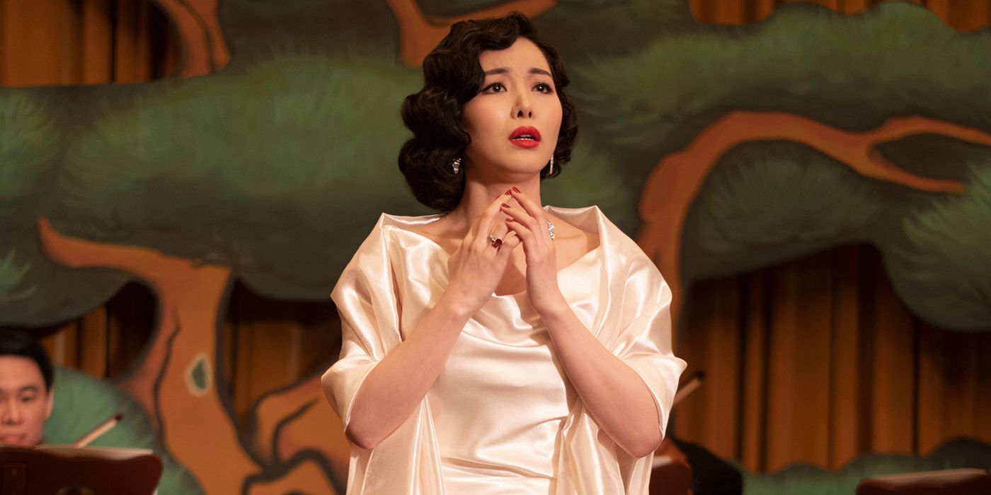 Ji Hye Lee as the singer on the boat, dressed in a white dress, singing in Korean in Pachinko