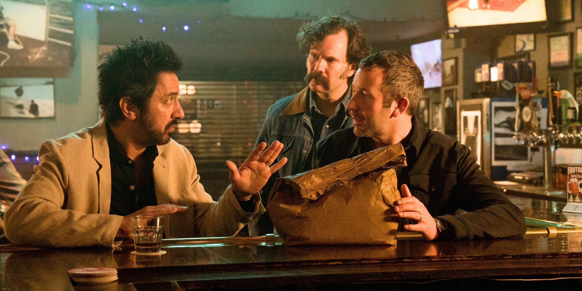 Ray Romano sitting next to Chris O'Dowd at a bar talking to him while Sean Bridger stands behind them in Get Shorty_TV Series