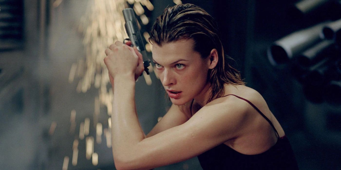 Alice (Milla Jovovich) holds a pistol as sparks ignite behind her in 'Resident Evil' (2002).