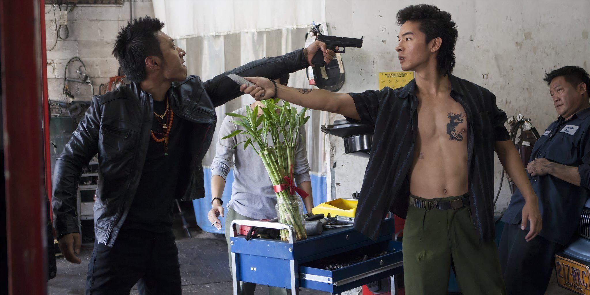 Two men threatening one another with weapons aimed at each other&rsquo;s heads in &lsquo;Revenge of the Green Dragons&rsquo; (2014)