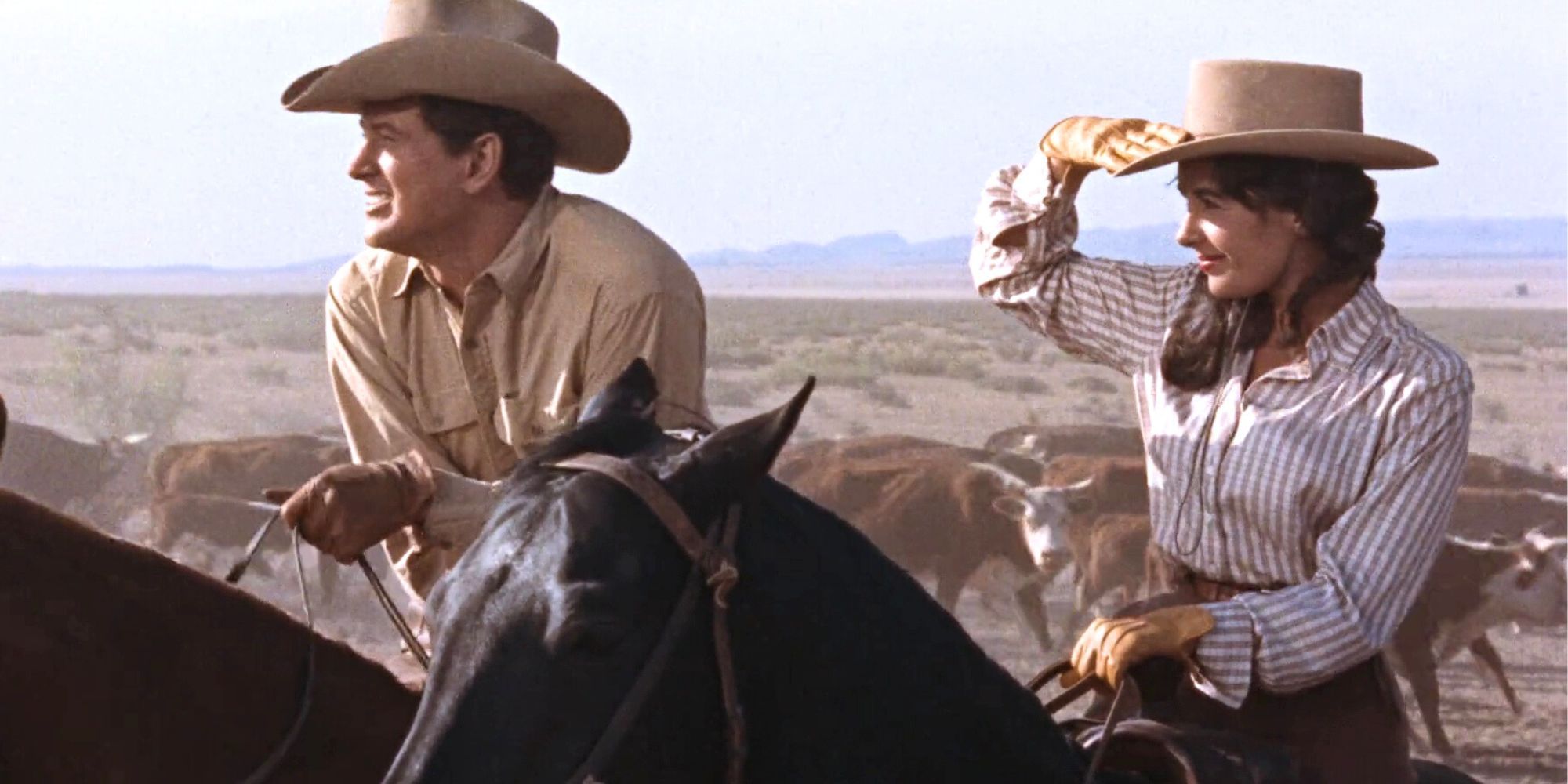 Rock Hudson and Elizabeth Taylor sitting on horses standing next to each in Giant (1956)